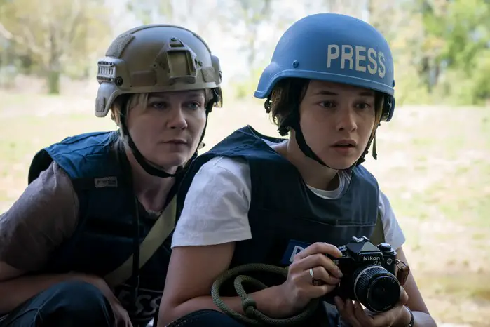 Kirsten Dunst as Lee and Cailee Spaeny as Jessie in Civil War wearing helmets and protective vests