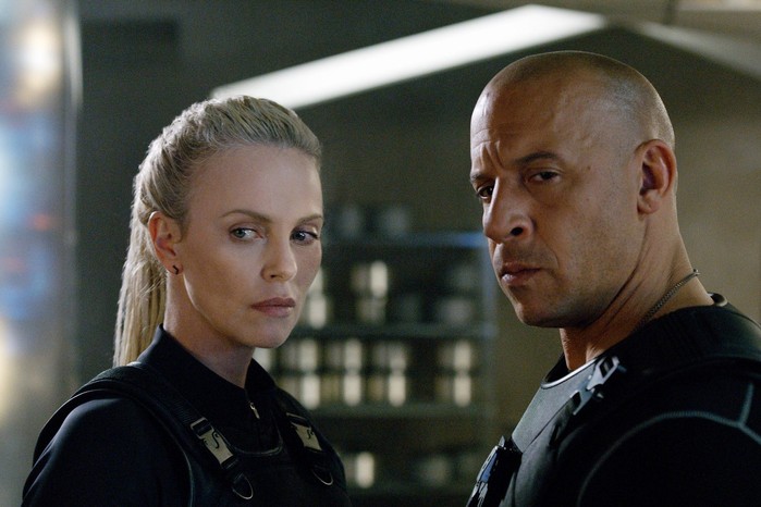 Vin Diesel as Dominic Toretto, Charlize Theron as Cipher in The Fate of the Furious, standing together, looking serious