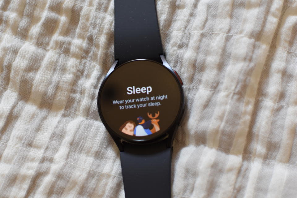 The Samsung Galaxy Watch placed on a blanket.  Its screen says 