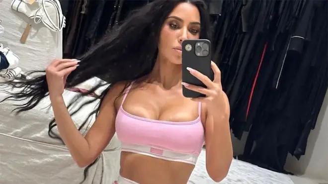 Kim Kardashian posing in pink Skims underwear for a mirror selfie