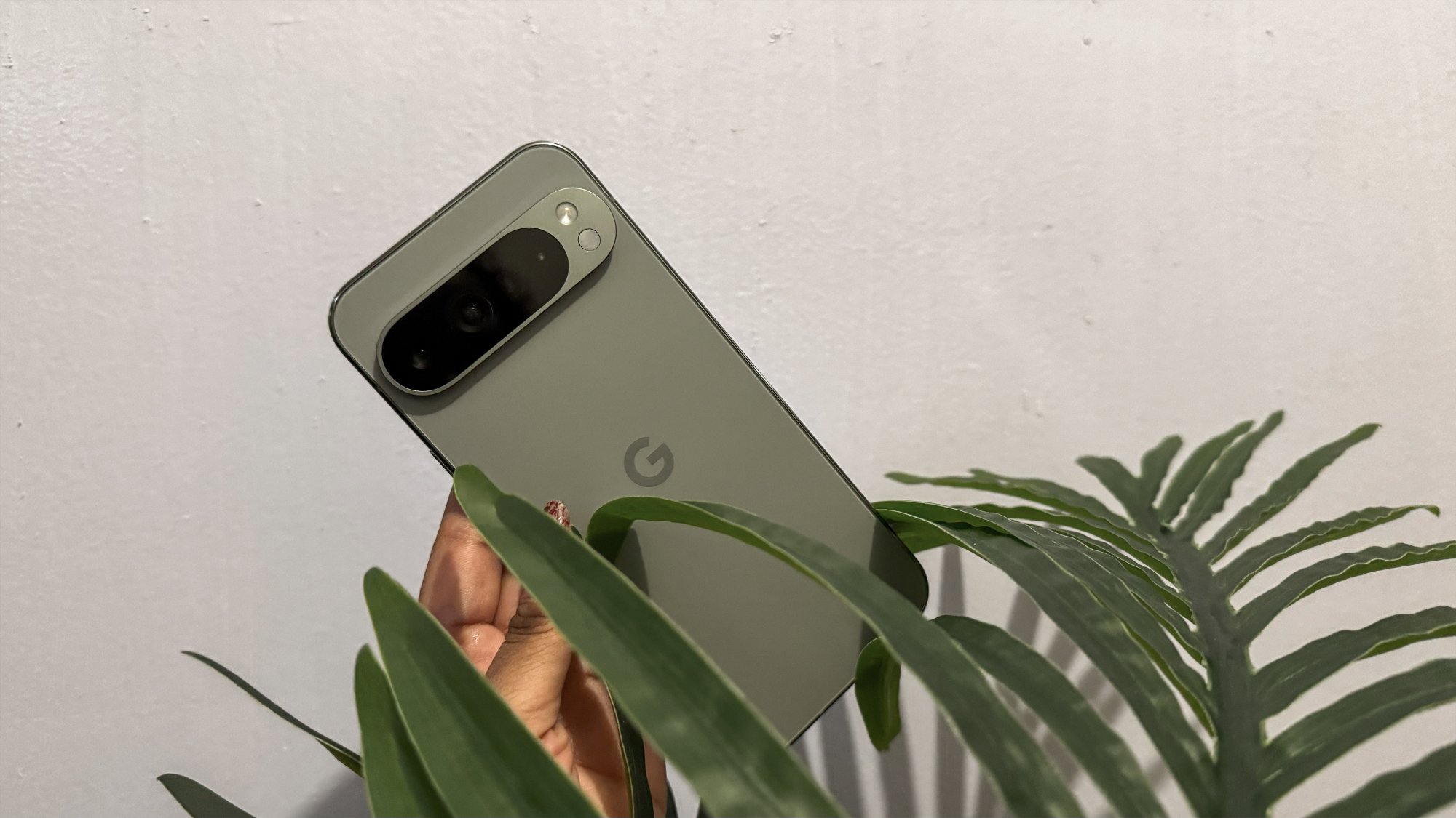 Google Pixel 9 Pro XL bir bitkinin yaprakları arasında tutuluyor.