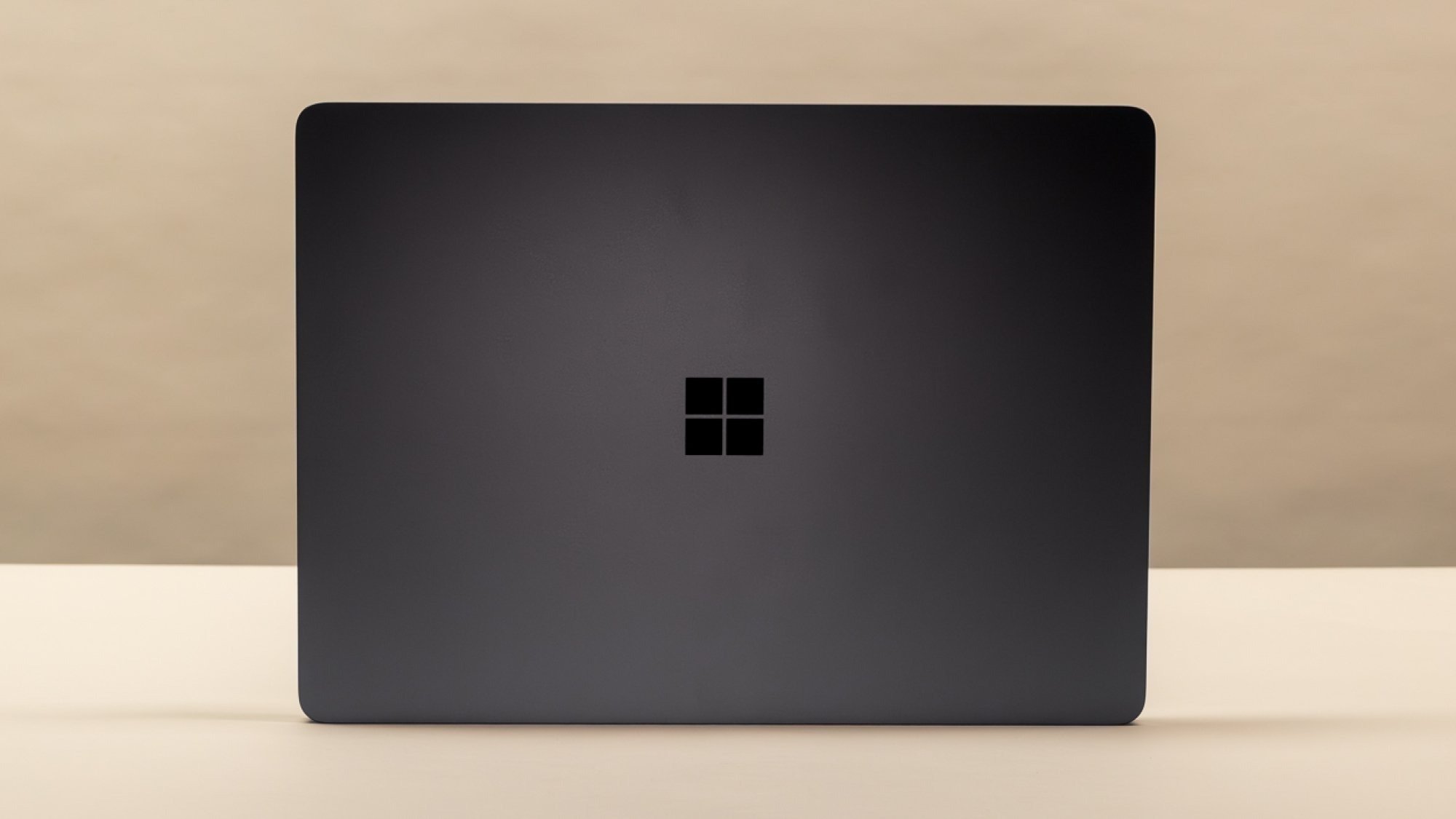 Bej renkli bir arka planın önünde Microsoft Surface Laptop 7